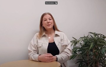 Nainen seisoo pöydän takana.